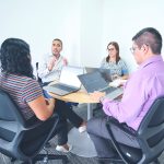 Trabajadores en oficina conversando sobre una negociación colectiva